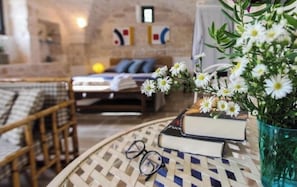 Relax in a warm and inviting space with a comfortable bed, wicker chair, and a peaceful reading nook.