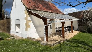 A single-story house with a sloped roof, a covered patio area, and a small garden. - Charming Cottage 6km from La Roche-Posay - Terrace, Garden, Baby Equipment, Pet Friendly, Wifi (La Roche-Posay)