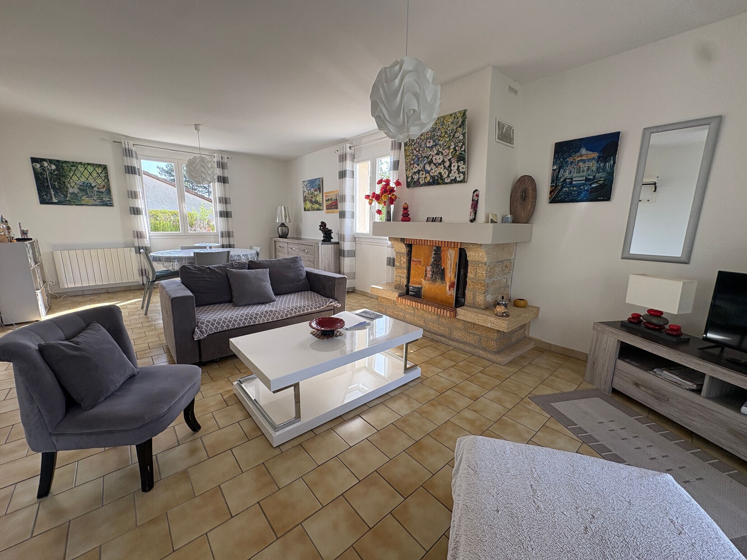 Ein modernes Wohnzimmer mit Kamin, einer Couch, einem Couchtisch und einem Fernseher.
