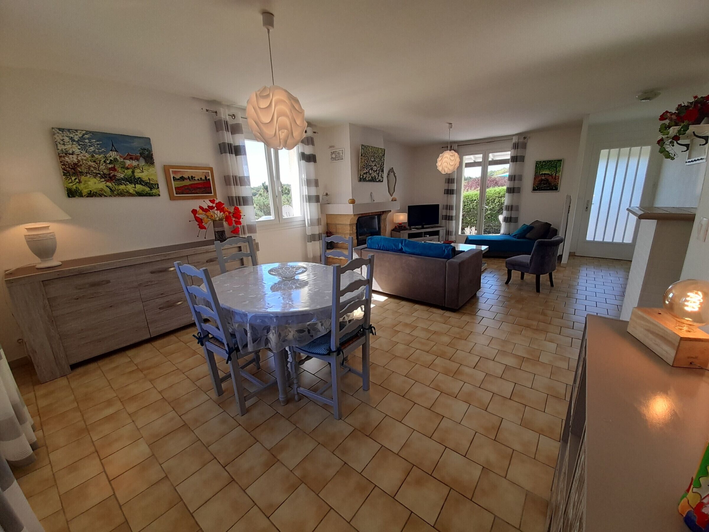 A modern kitchen with a dining table, chairs, and a TV.