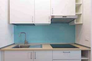 Kylskåp, mikrovågsugn, spishäll och grytor/köksredskap