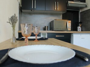 A kitchen with dark cabinets, a microwave, and a sink. - Cozy Studio with Wi-Fi Near La Roche-Posay Center and Thermal Spas (La Roche-Posay)