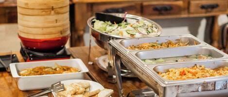 A buffet table with various dishes and a large wooden barrel.