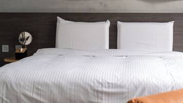 Un dormitorio moderno con una cama grande, dos almohadas, una mesita de noche con espejo y una obra de arte en la pared.