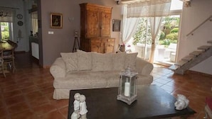 A living room with a sofa, a cabinet, and a table with a candle. - Les Jarrières (Dame-Marie-les-Bois)