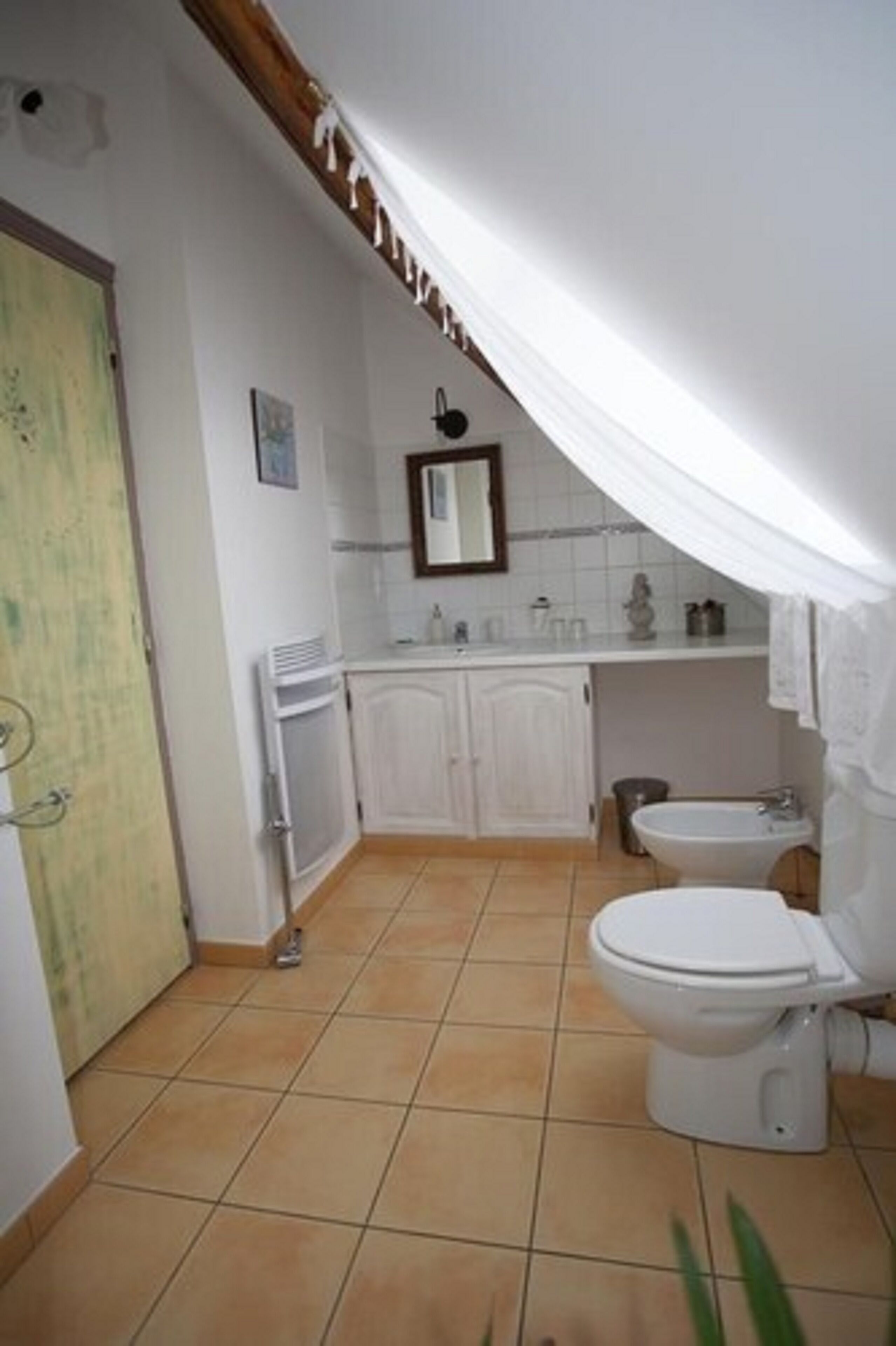 Et badeværelse med toilet, bidet og håndvask.