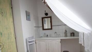 Et badeværelse med toilet, bidet og håndvask.