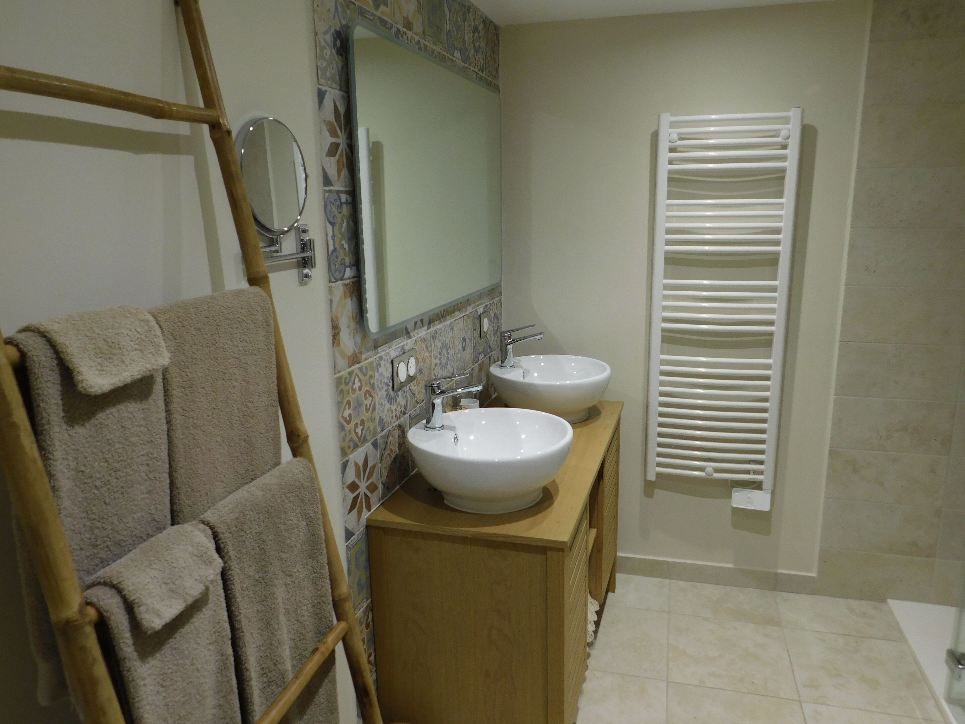A bathroom with two sinks, a mirror, and a towel rack.