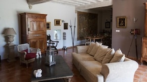 A cozy living room with a wooden cabinet, a sofa, a table, and a chair. - Les Jarrières (Dame-Marie-les-Bois)