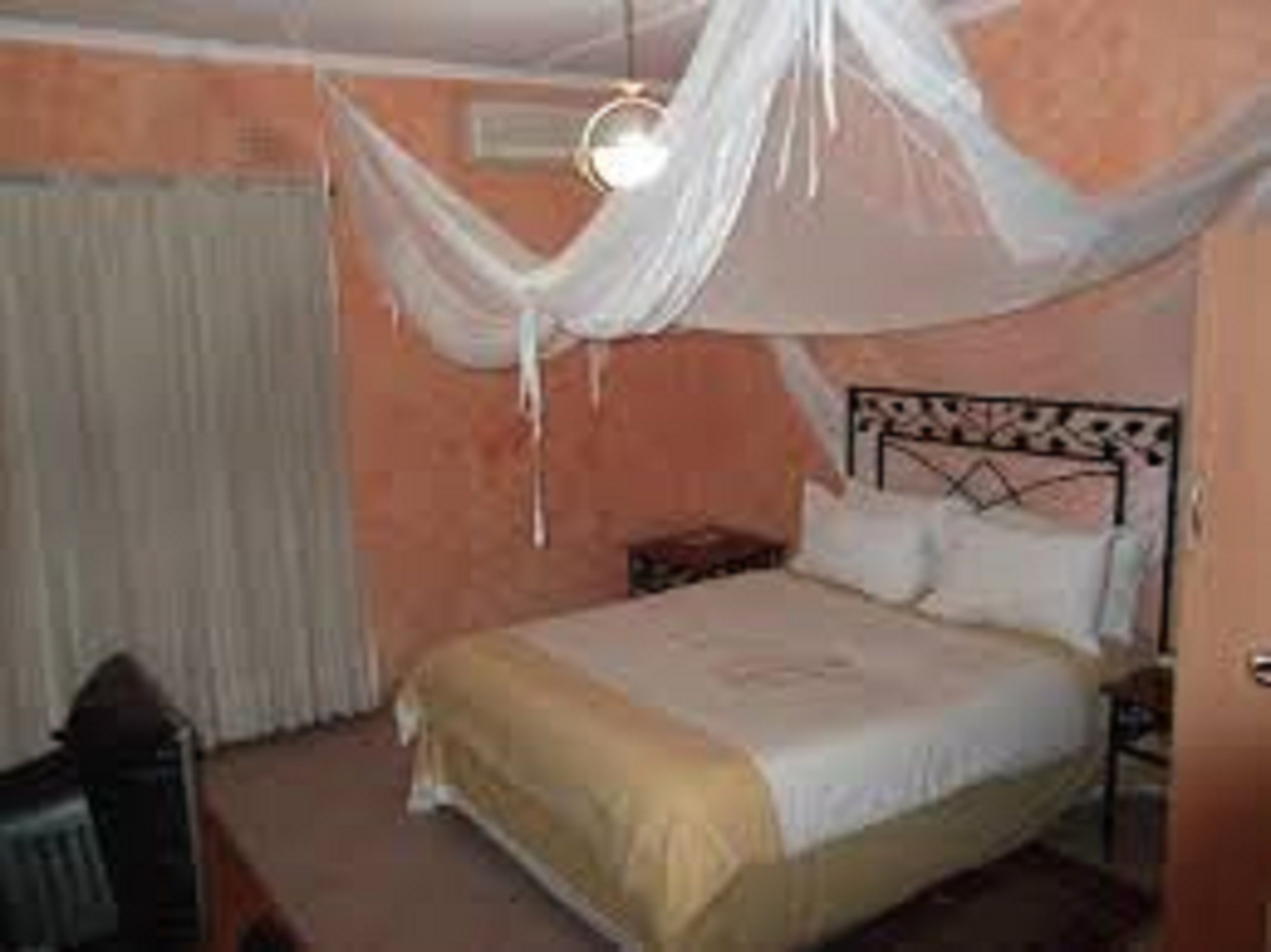 A bedroom with a bed, a nightstand, and a chair.
