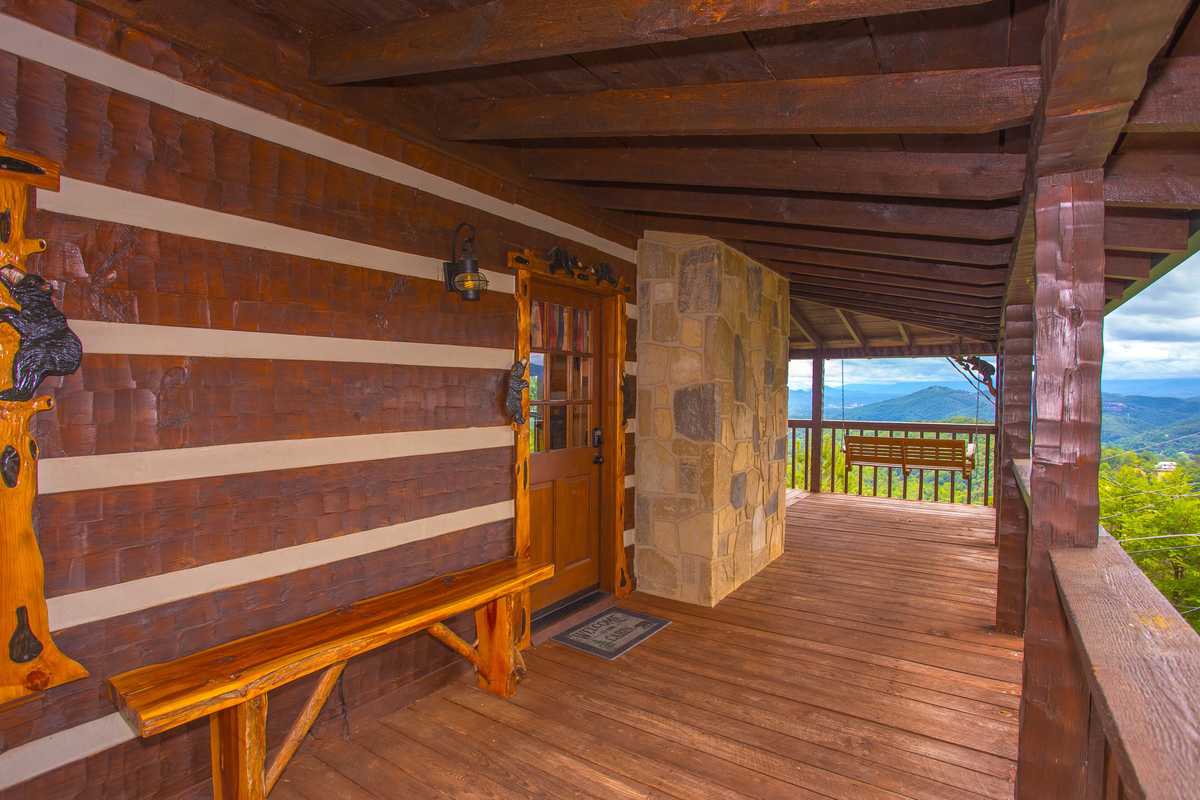 Eine Holzhütte mit Steinwand, einer Holzbank und einer Holztür.