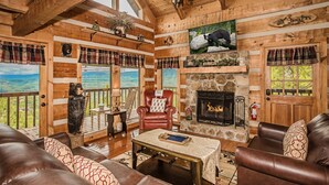 Un intérieur de chalet chaleureux avec une cheminée, des meubles en cuir et une vue magnifique.