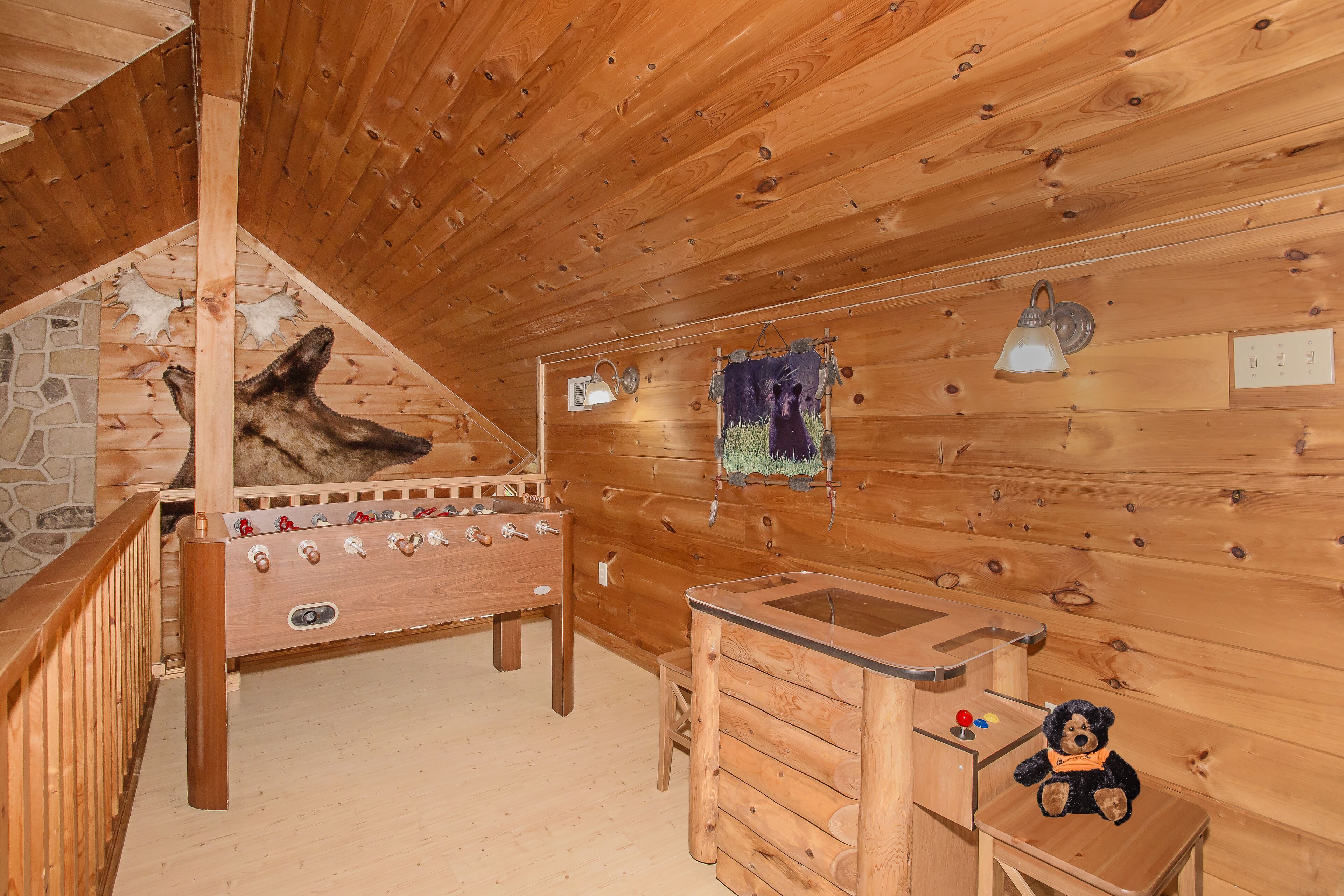 Ein Holzinnenraum mit Holztisch, kleiner Holzschrank und einer Bärenfigur.