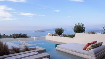 Une piscine à débordement moderne offrant une vue sur la mer et les îles lointaines.