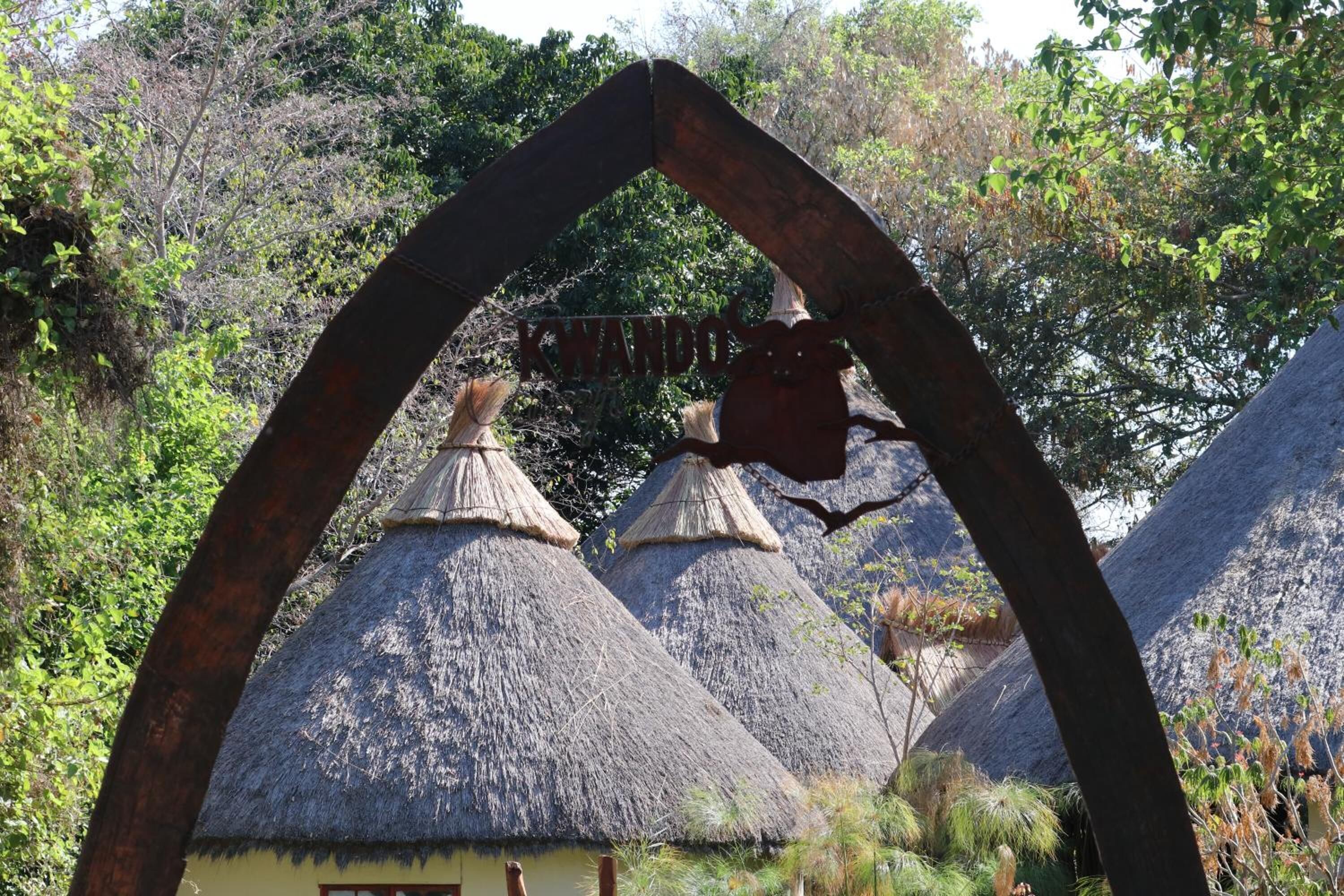 Thatched-roof huts with a sign above them.
