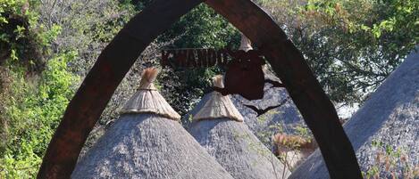 Thatched-roof huts with a sign above them.