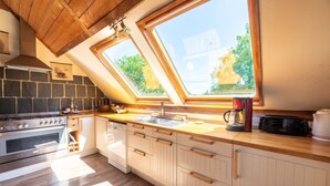 A modern kitchen with a skylight, built-in oven, and a coffee maker. - Quaint Holiday Home in Ferce (Ferce)