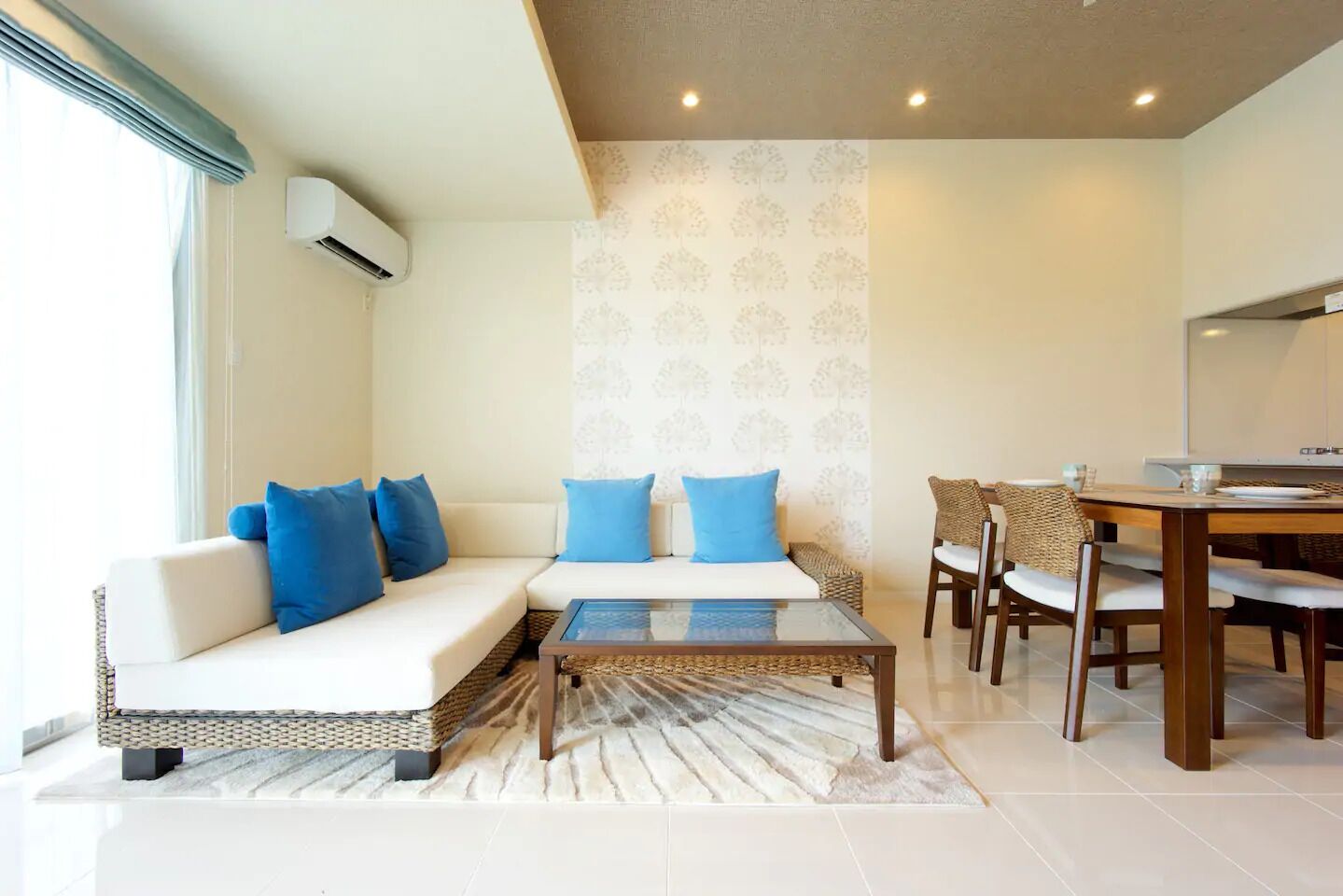 A modern living room with a sofa, coffee table, and dining area.
