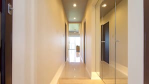 A hallway with a tiled floor, a ceiling with recessed lighting, and a door on the right. - Longvacation Okinawa 109 (Onna)