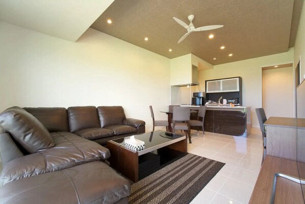 Relax in this stylish living room with a comfortable sofa, coffee table, and kitchen area.
