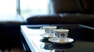 Two white cups with blue floral designs on a reflective surface.