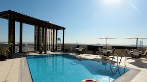 A rooftop pool with a clear view of the city skyline, surrounded by lounge chairs and umbrellas. - Marbella Executive 2 Bedrooms Balcony (Dubai)