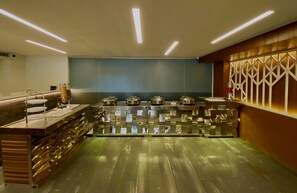 A modern kitchen with stainless steel appliances, a wooden counter, and a decorative wall panel. - Ace Iconic (Greater Noida)