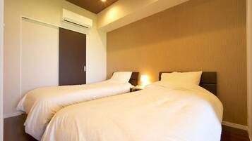 Une chambre d’hôtel avec deux lits, un mur décoratif en bois et un luminaire au plafond.