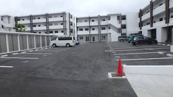 A parking lot with multiple cars and a building in the background.