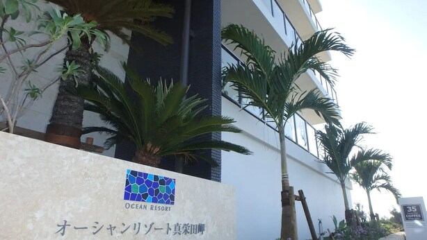 A sign for Ocean Resort with a logo and Japanese text. - Longvacation Okinawa 209 (Onna)
