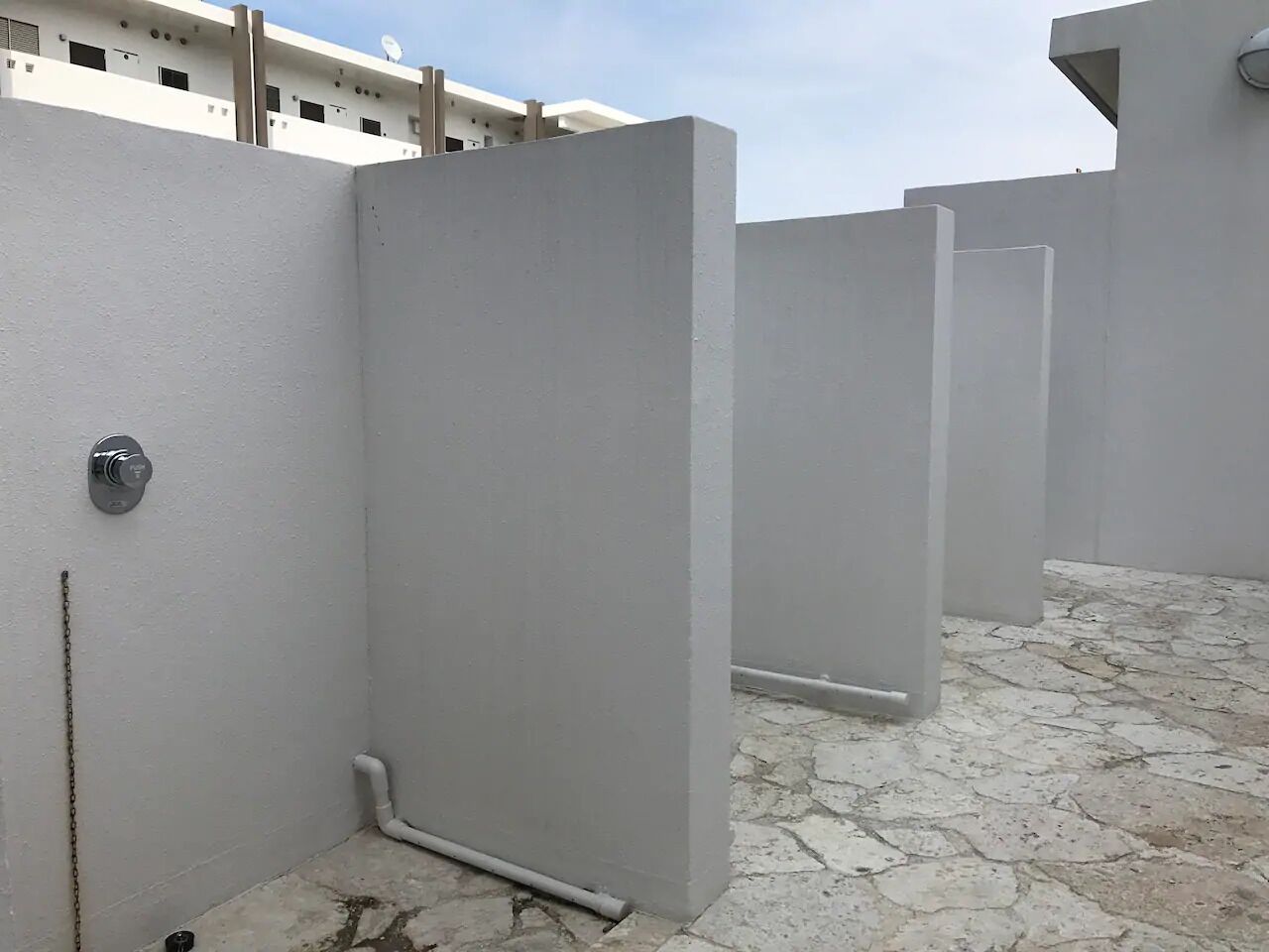 A modern building with a clean, white exterior and a stone-tiled floor.