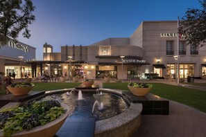 Un centro comercial con tiendas Macy's y Saks Fifth Avenue, una fuente y zonas de estar al aire libre.
