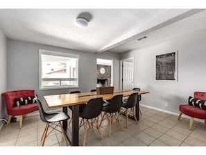 A dining area with a wooden table, black chairs, and red sofas. - ELM - Modern 4BD / Private Pool & Walk to Biltmore (Phoenix)