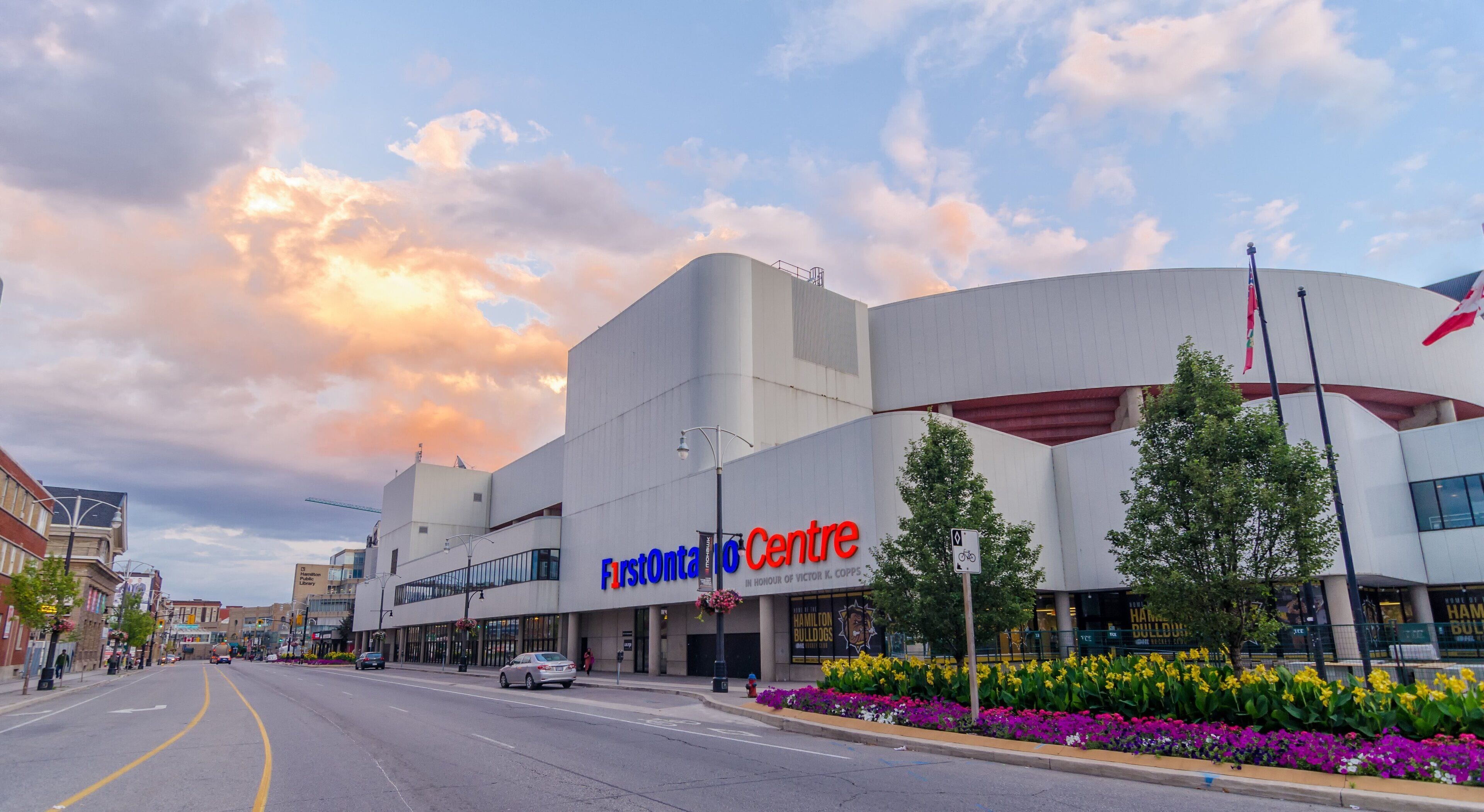 Un bâtiment moderne à la façade incurvée, sur lequel on peut lire l’inscription « FirstOntario Centre ».