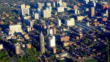 Vista aérea de un paisaje urbano con numerosos edificios altos, carreteras y zonas verdes.