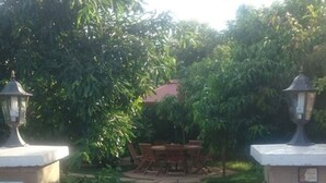 A pathway leading to a seating area with a table and chairs, flanked by lamp posts and a sign indicating a smoking zone. - Desert Rose Resort (Kisumu)