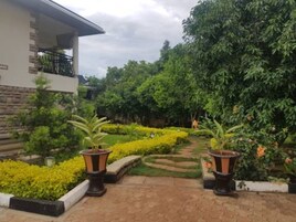 Uma trilha que leva a um edifício com fachada de pedra e varanda.