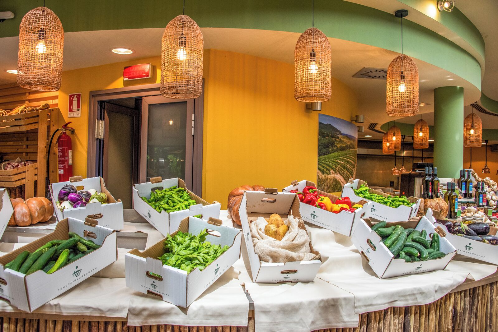 Buffet amb diverses fruites i verdures fresques presentades en caixes.