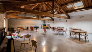 Una habitación amplia con un alto techo de madera, una mesa de billar y diferentes opciones de asientos.