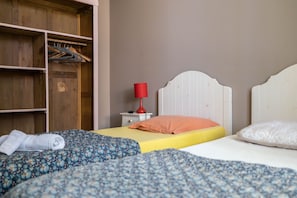 Un dormitorio con cama, armario, mesita de noche y lámpara.