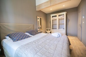 Ein Schlafzimmer mit Bett, Stuhl, Fenster und Kleiderschrank.