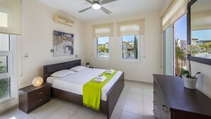 A bedroom with a bed, bedside tables, a ceiling fan, and a dresser. - Protaras Villa Marilia Near Fig Tree Bay Beach (Protaras)