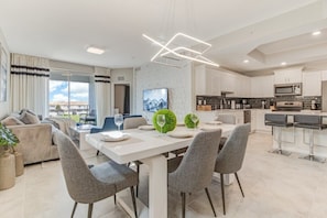 A modern kitchen with white cabinets, a built-in oven, and a microwave.