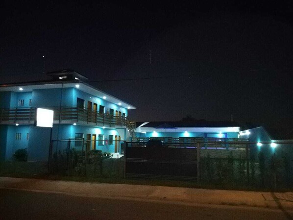 A two-story building with a balcony and a gated entrance. - Energia do Vento Pousada (Ilha Comprida)