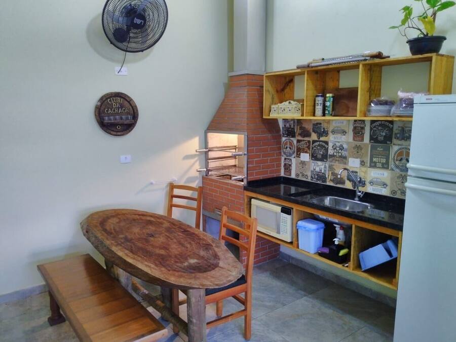 Una cocina compacta con horno de ladrillo, mesa y sillas de madera.