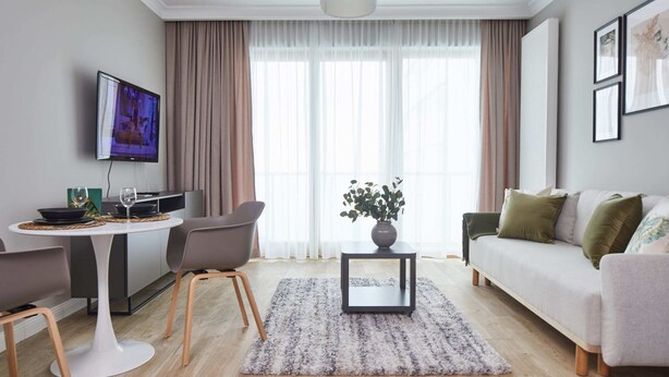 Een moderne woonkamer met een bank, een eettafel en een televisie.