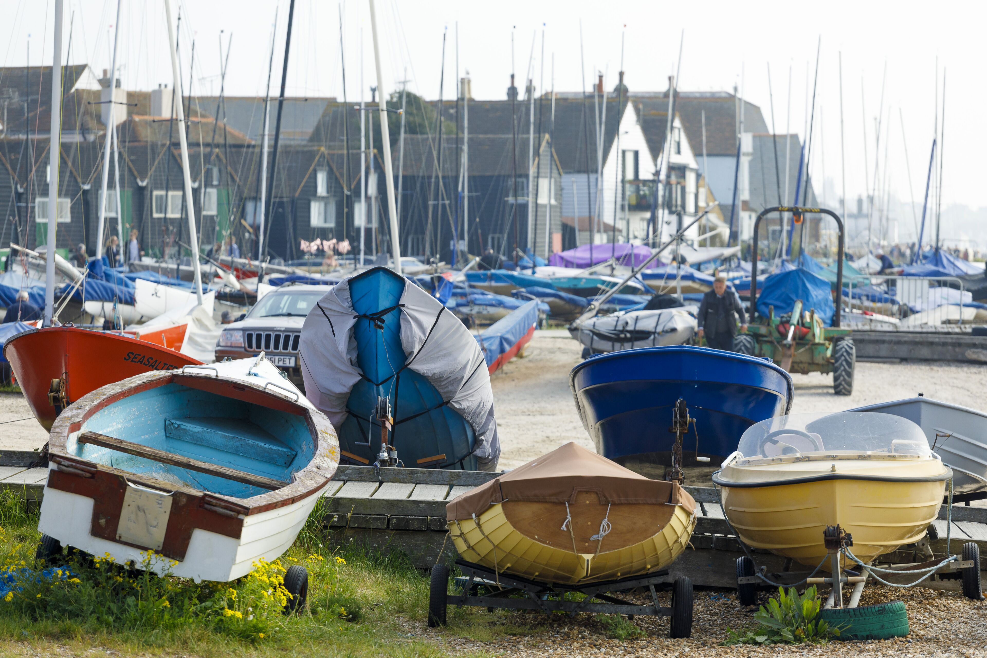 A marina with various boats docked, including a rowboat and a small motorboat.