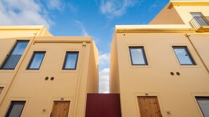 Un bâtiment doté de nombreuses fenêtres et portes, dont certaines donnent sur des balcons.