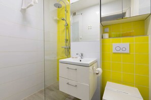 Ein Badezimmer mit Dusche, Waschbecken und Toilette.
