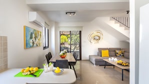 A modern kitchen with a dining area, a staircase, and a living room with a sofa and coffee table. - Protaras Villa Angela Nefeli (Protaras)